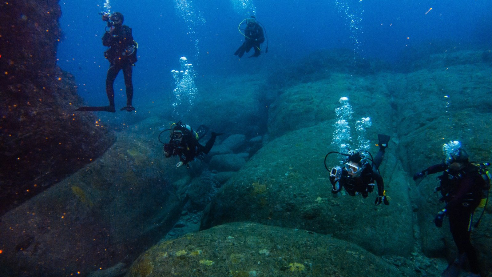 Scuba divers exploring the underwater Yonaguni Monument