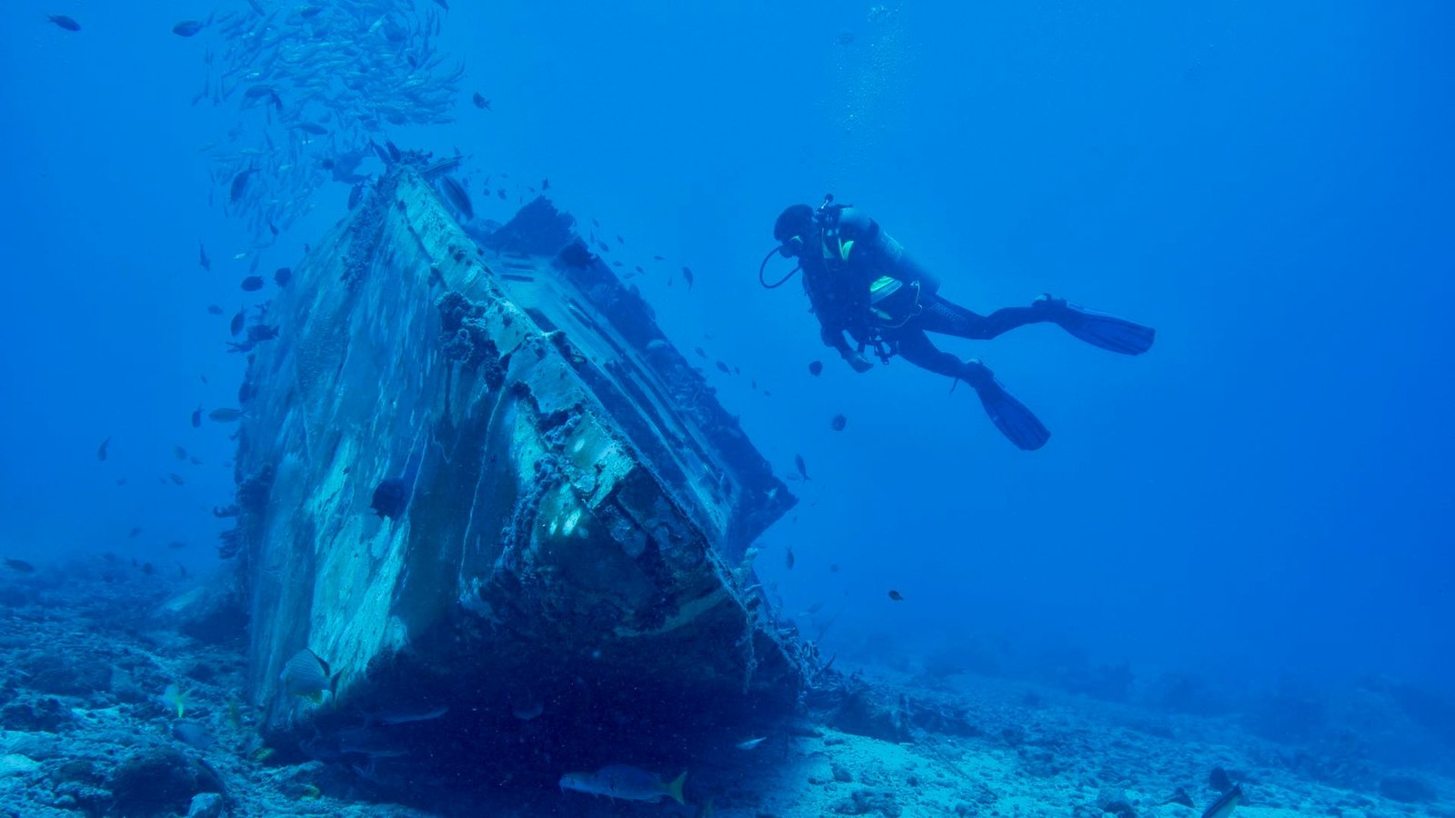 Scuba diver exploring a shipwreck in the ocean