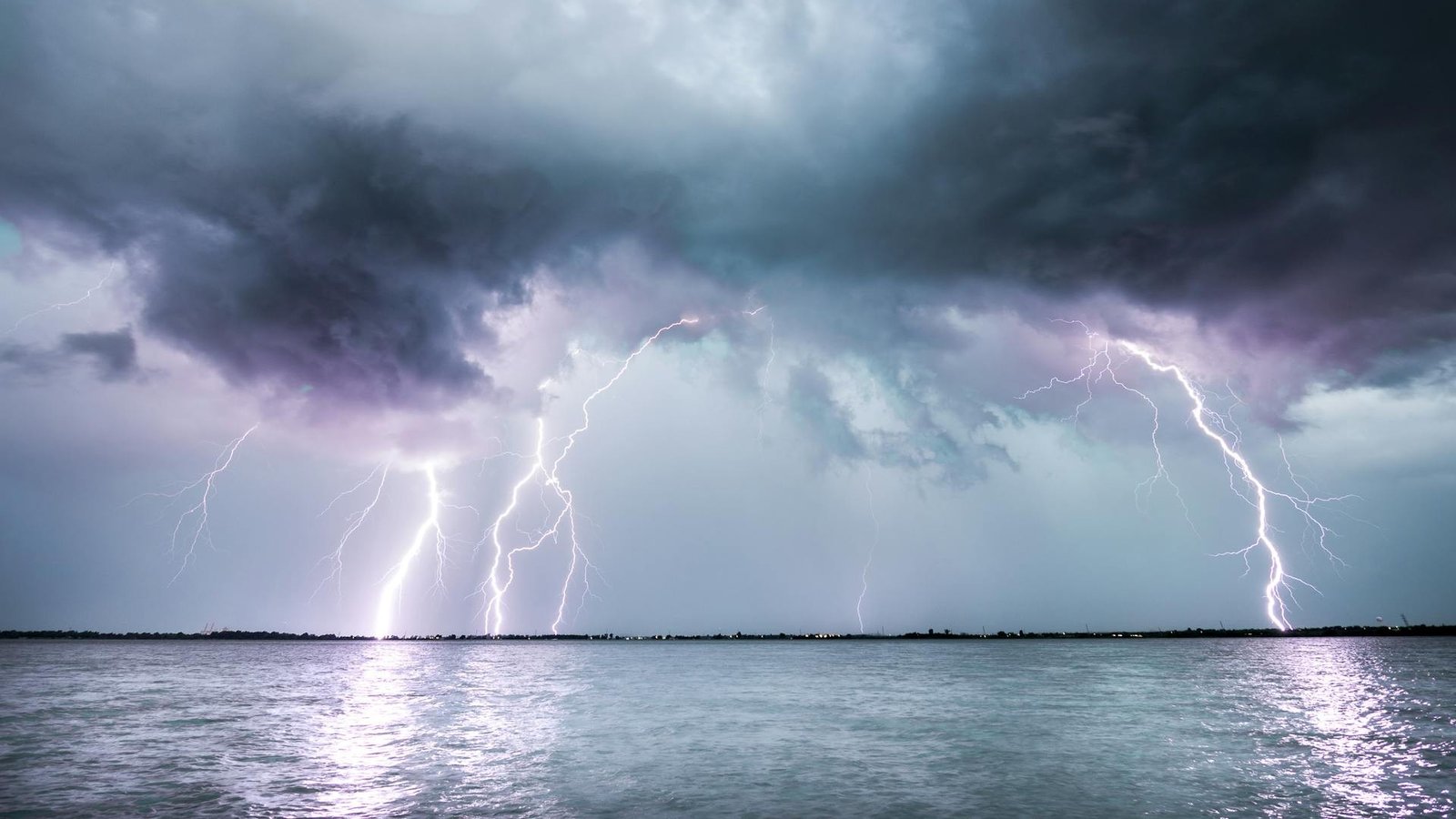 Lightning and dark clouds over body of water